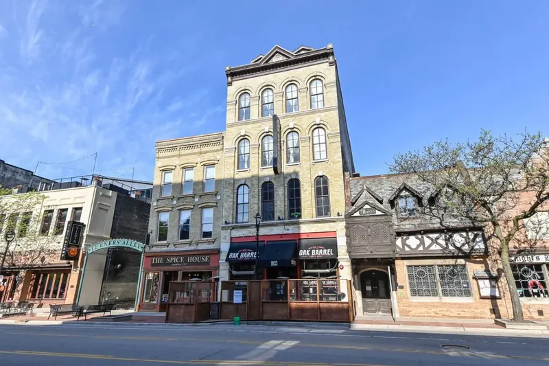 The cream brick building on Old World Third Street with Oak Barrel Public House at street level and the rentals above